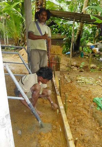 石工さんの指示の下、スタッフのサンパットくんのお兄さんが溝を作る準備をしています。