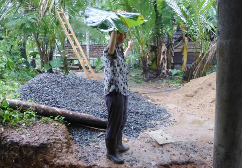 コンポストセンターの視察中、突然の豪雨で、傘を持参し忘れた高橋は葉っぱの傘で帰ります。